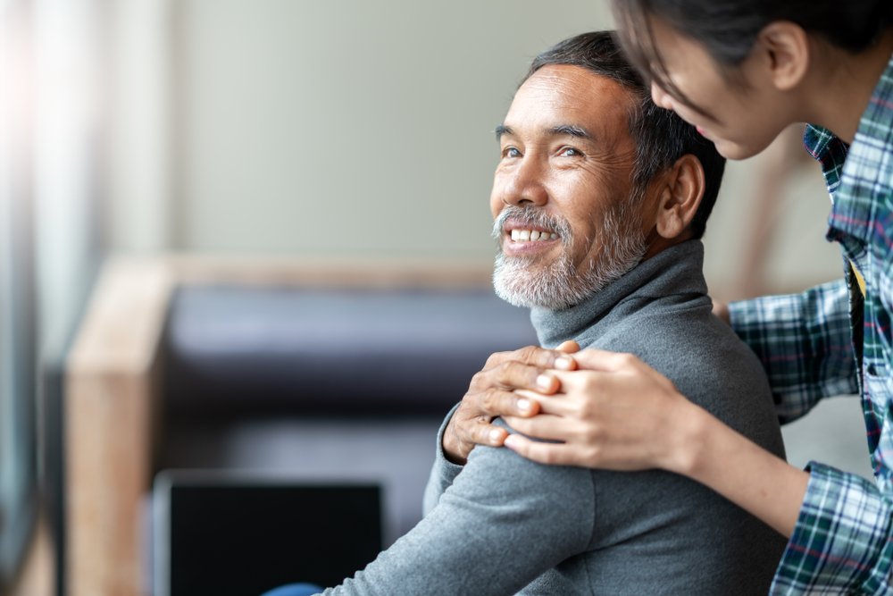 A young woman touching her father's shoulder