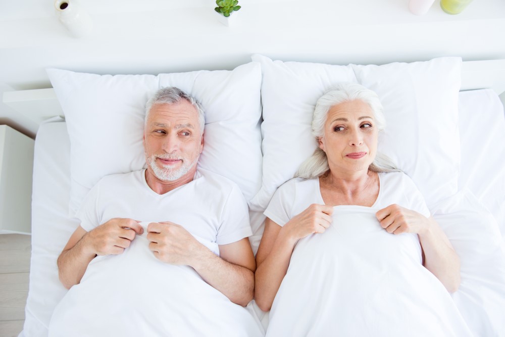 A romantic senior couple lying in bed