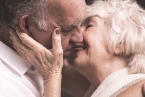 A senior couple kissing, focusing on the idea of elderly parents and sex