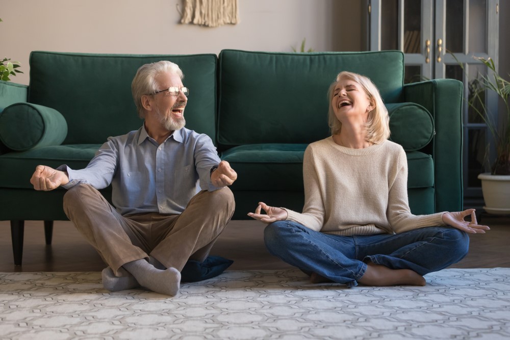 Two seniors trying to do yoga and laughing