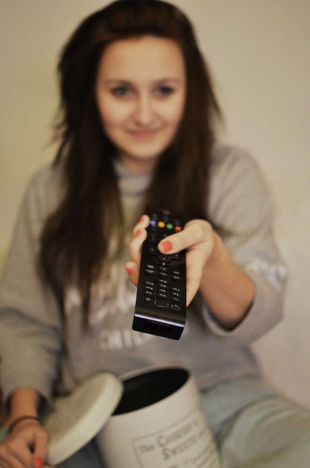 Girl with remote watching TV