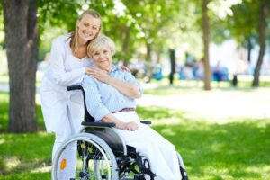 A caregiver and a woman in a wheelchair, looking at how someone can become a paid professional caregiver