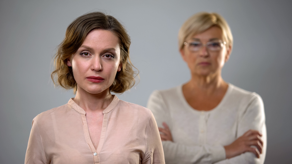 A woman standing in front of her aging mother, based on the idea that caring for my elderly mother is killing me