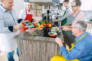 A group of seniors taking an in-person cooking class, highlighting the benefits of cooking classes for seniors