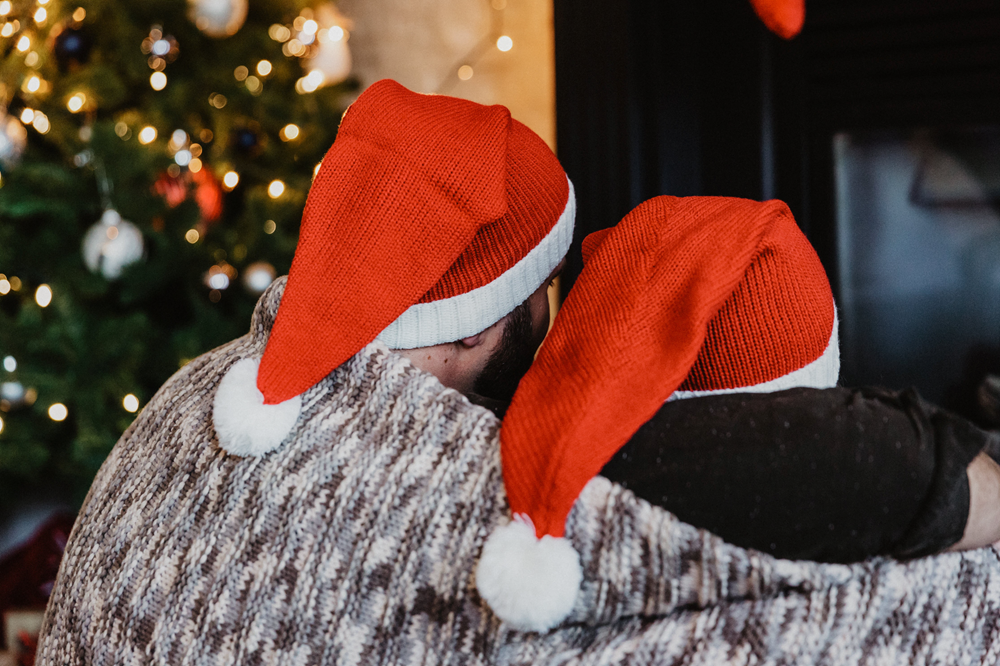 Two people wearing red and white Christmas hats