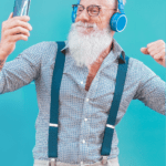 A man in suspenders and blue headphones in front of a blue background