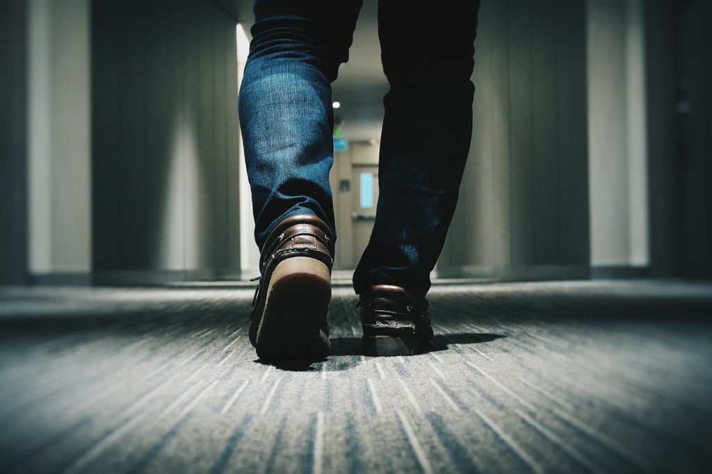 Someone walking down the hall, highlighting adaptive shoes for seniors and their potential benefits.