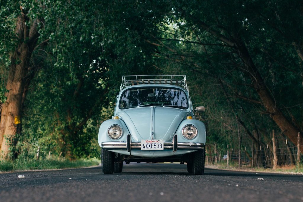 A light blue bug car, looking at the idea of traveling with seniors. 