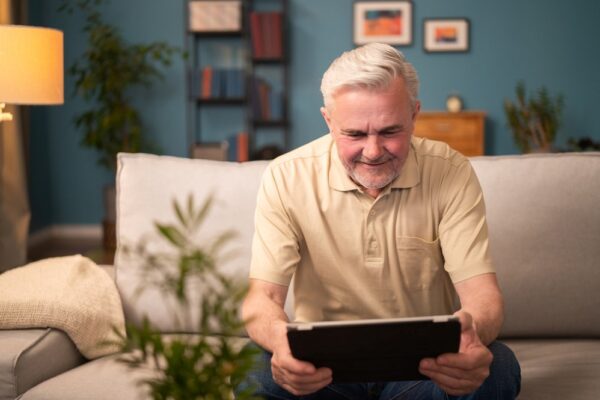 An elderly man playing games on a tablet, highlighting the idea of tablet apps for seniors