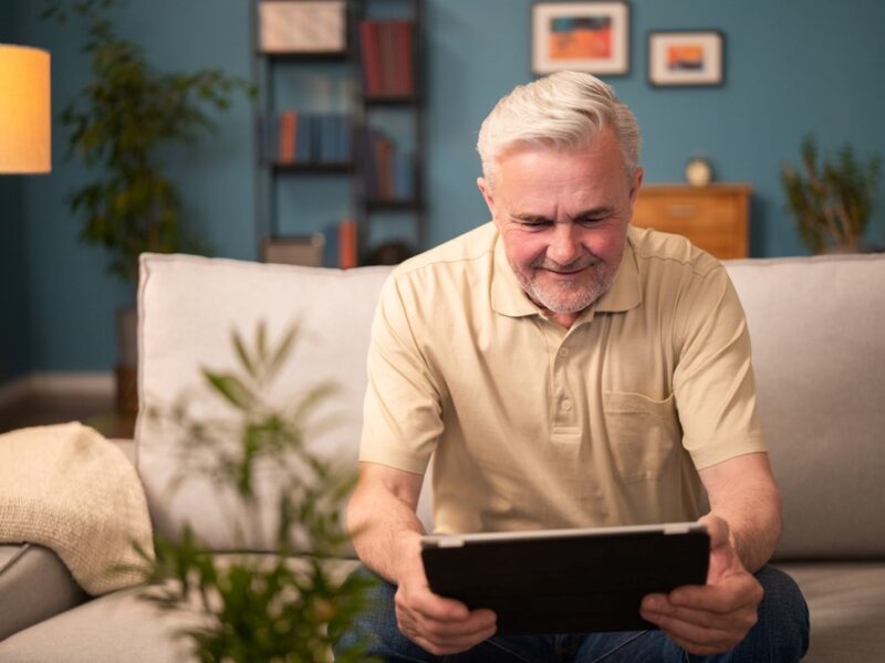 An elderly man playing games on a tablet, highlighting the idea of tablet apps for seniors