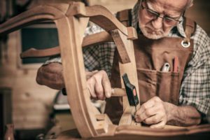 A senior man working on carpentry at home