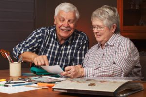 A retired couple using a scrapbook as one of their holiday activities for seniors