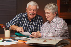 A retired couple using a scrapbook as one of their holiday activities for seniors