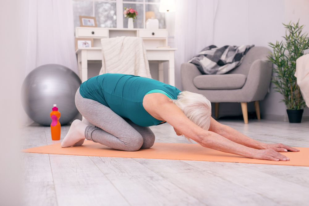 A mature woman doing yoga at home