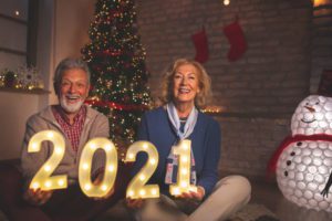 A senior couple celebrating 2021 with a sign