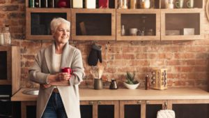 A happy senior woman standing in her kitchen