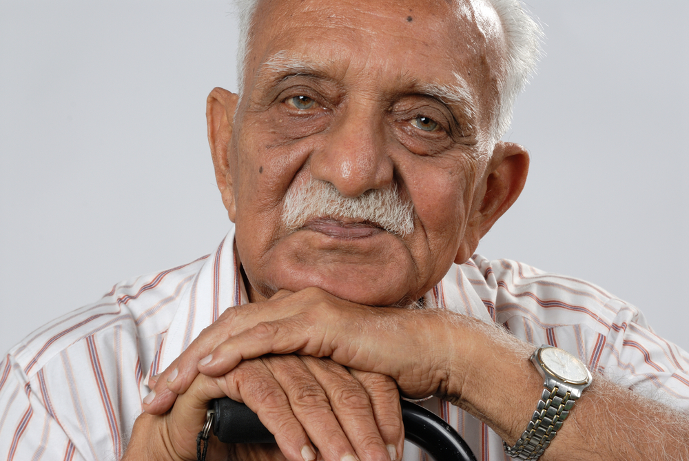 A senior Pakistani resting his chin on his hands