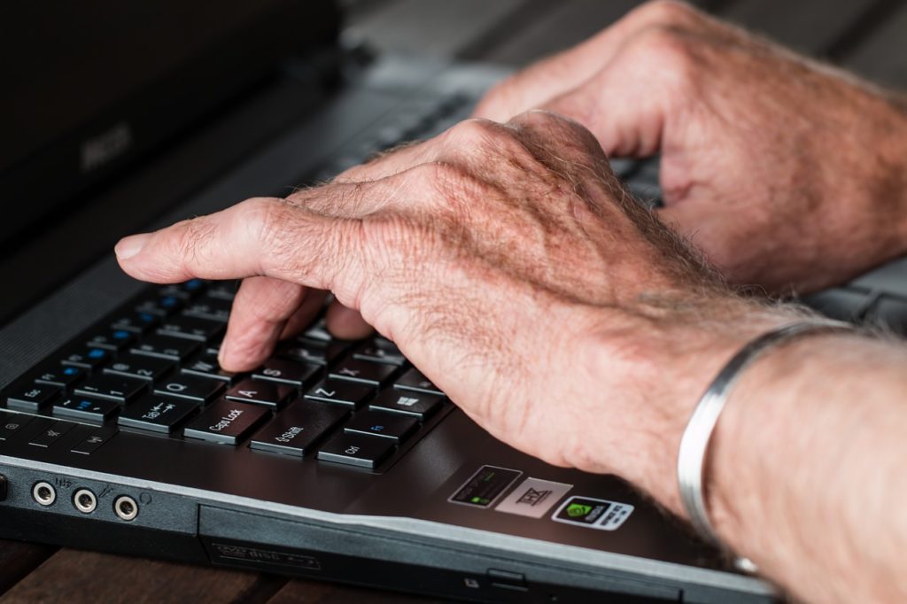 A senior typing on a laptop