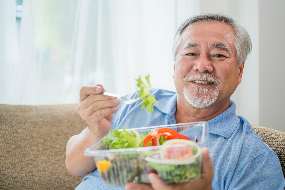 A Chinese senior eating a salad