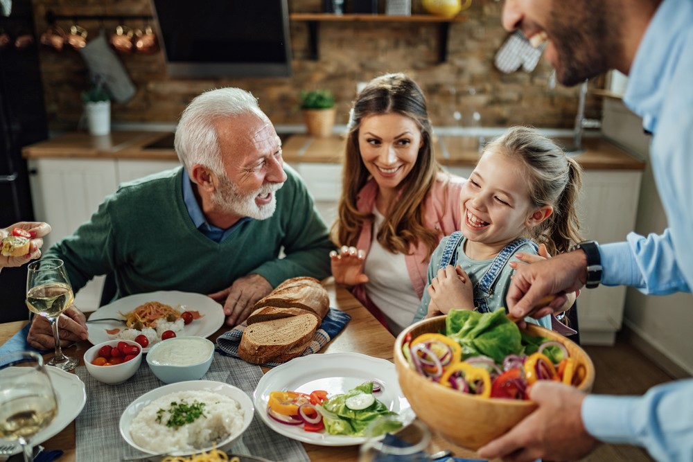 A senior eating with his family, as an example of freezer meals for seniors