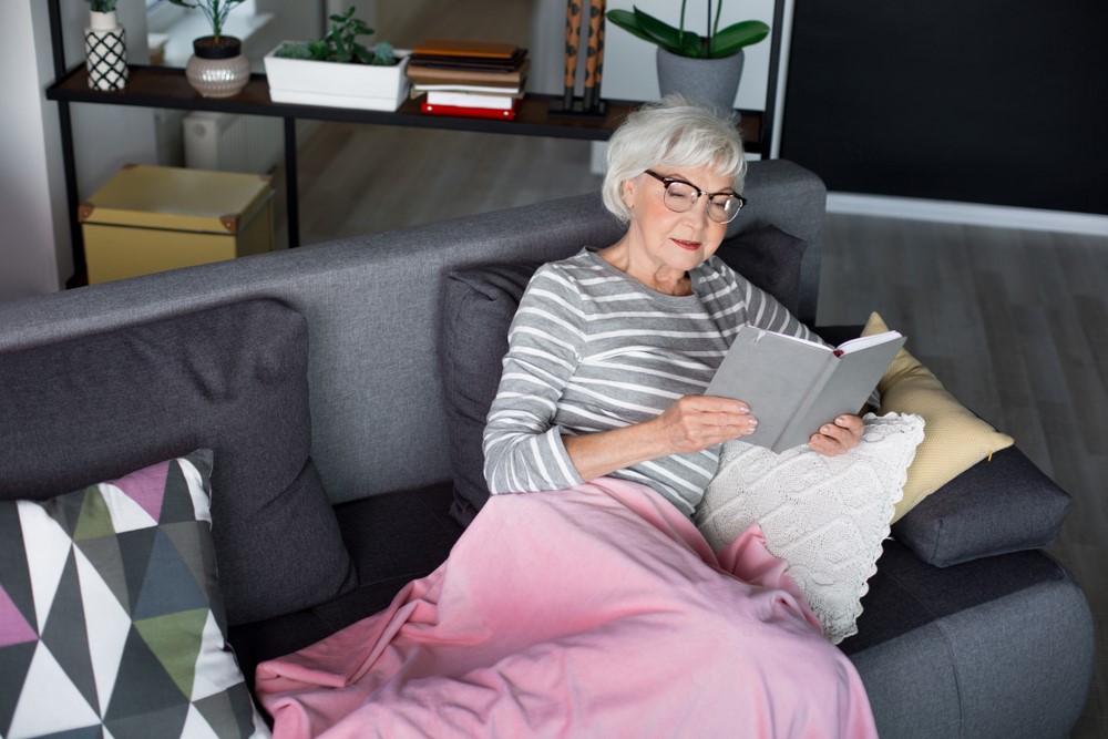 A senior man lying down with a weighted blanket