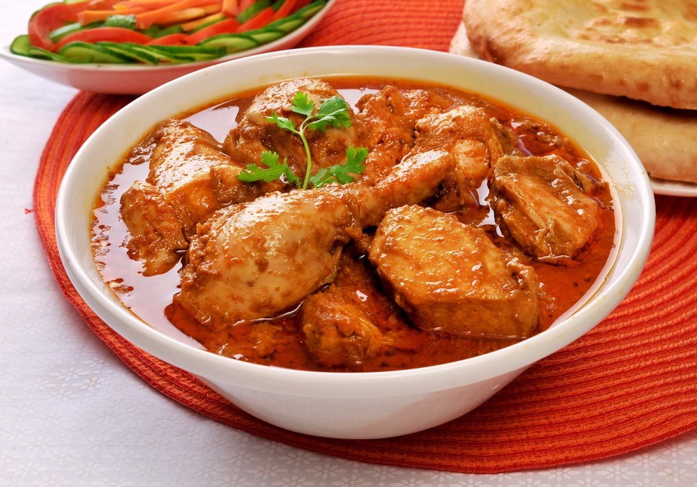 A white bowl filled with chicken korma