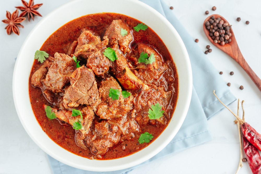 A white dish of slow cooker lamb curry