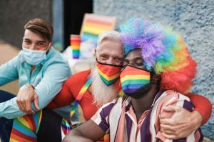 A group of pride parade members wearing rainbows, highlighting the idea of an aging father who came out as gay