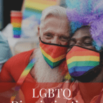 A senior and a younger African American man, both wearing rainbow masks as part of a LGBT parade