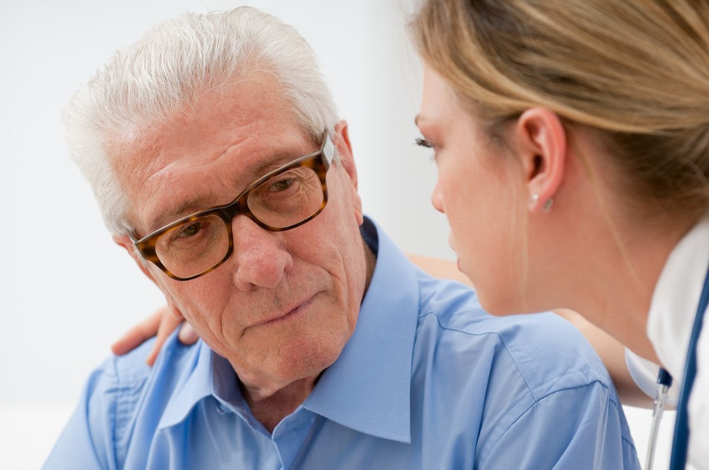 A senior man talking to a nurse