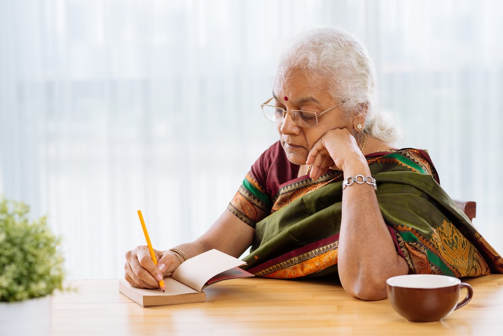 An Indian senior writing in a journal