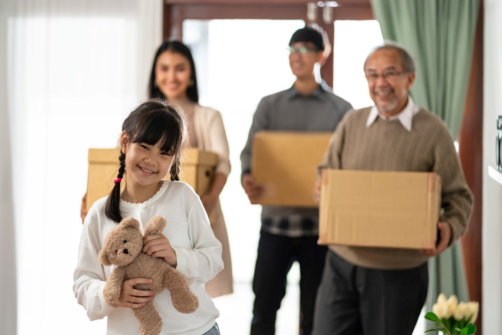 A child, her parents, and grandfather preparing to move to a new house