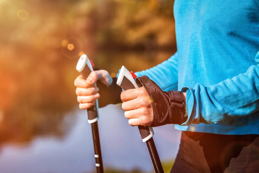 A close up image of a senior holding Nordic poles