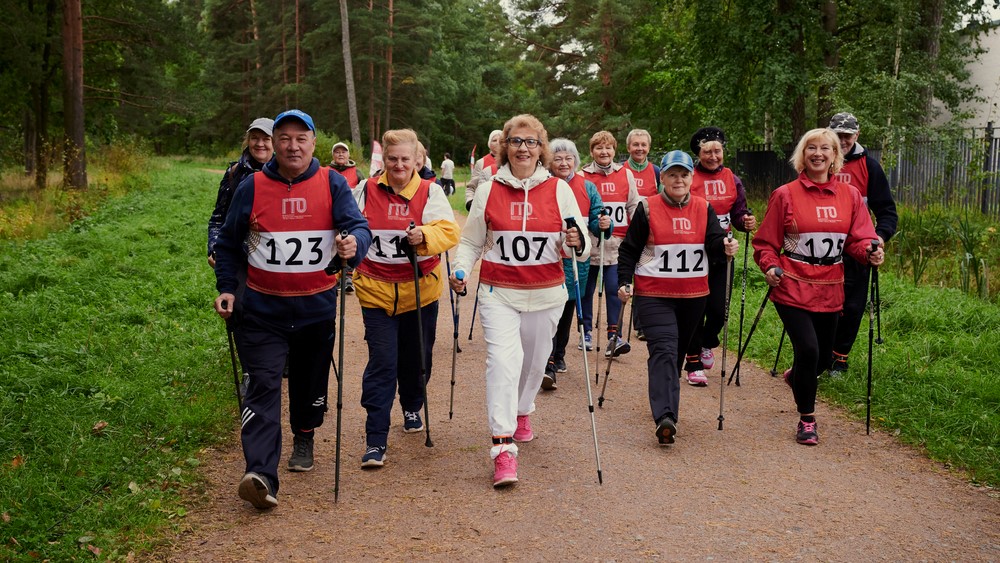 A group of seniors doing urbal poling or Nordic walking, wearing racing numbers