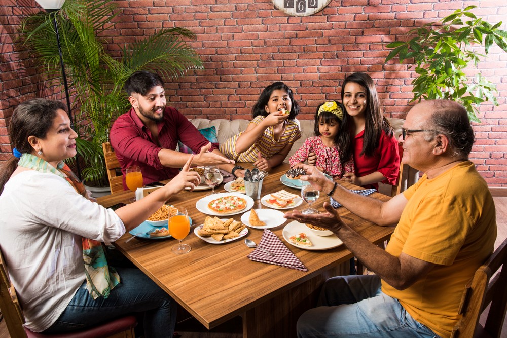 A multigenerational Indian family sitting outside