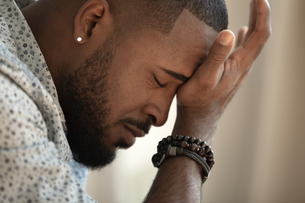 A sad African American man in his room