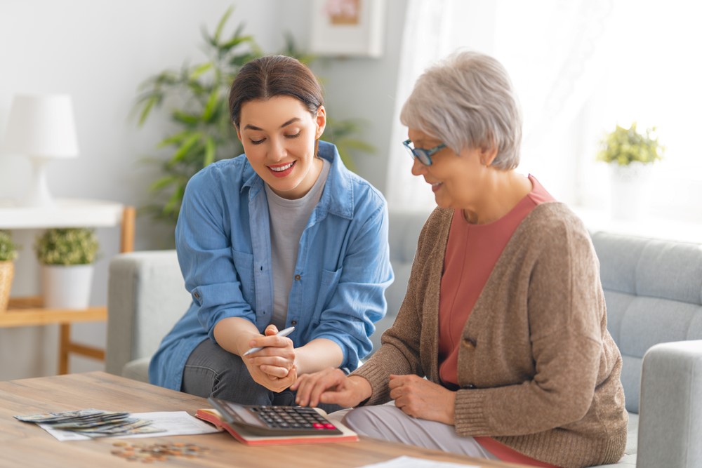 An elderly woman and her daughter looking at finances