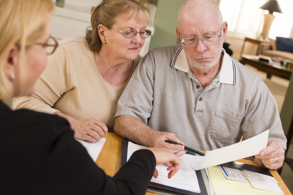 Two seniors looking at paperwork for financial planning or a trust