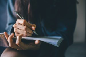 A young woman writing in her journal