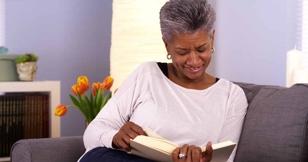 An African American woman reading a self help book