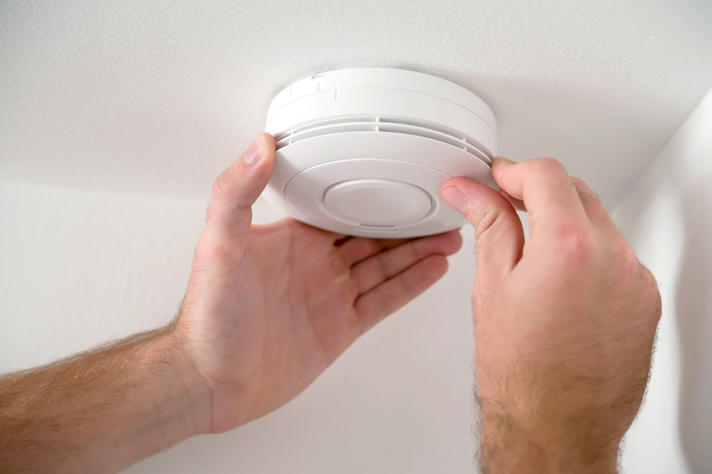 A man installing a smoke alarm