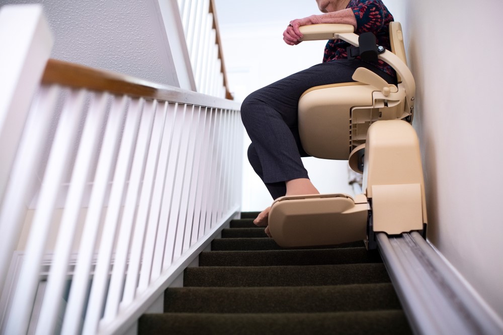 A senior using a stair chair lift