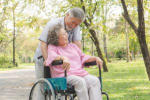 A senior woman in a wheelchair with her husband, highlighting the idea of wheelchairs for seniors