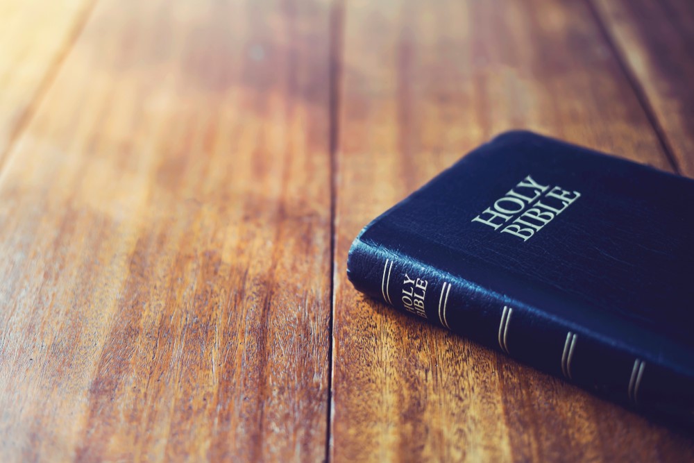 A man with a bible praying