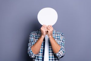 A man holding a circle in front of his face, highlighting the idea of identity loss