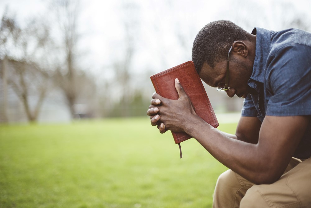 A man with a bible praying