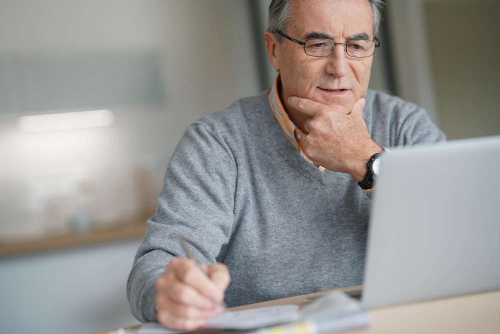 A senior man doing some research or participating in online therapy