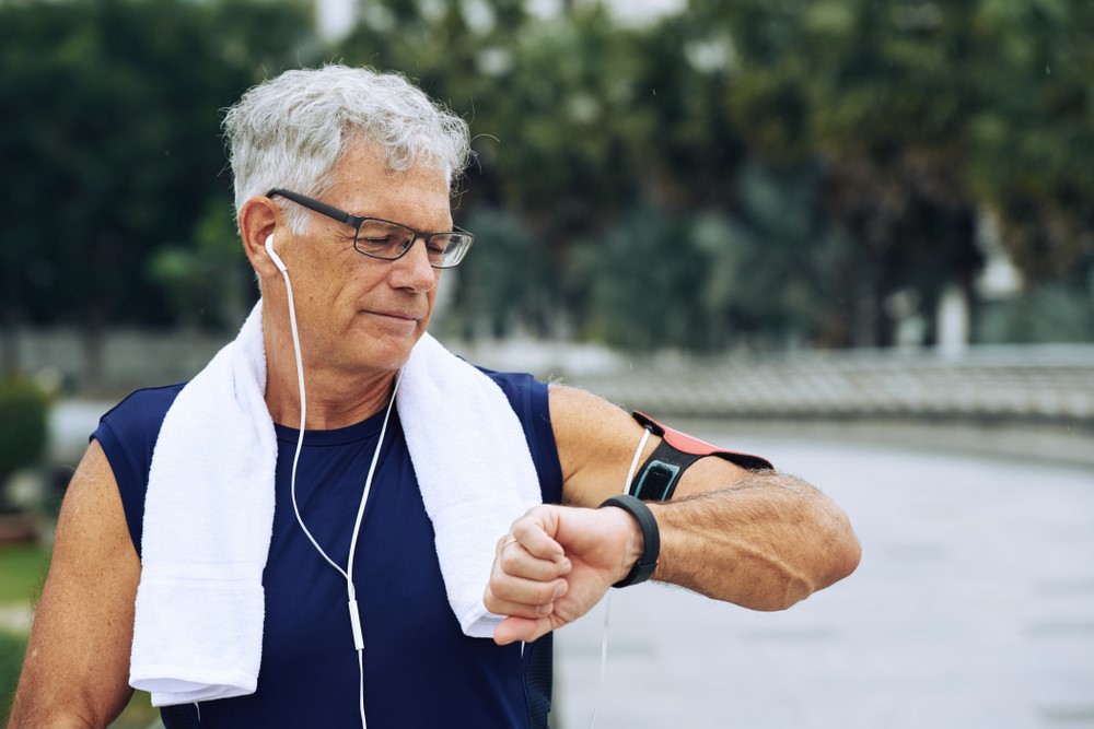 A senior man looking at his activity tracker