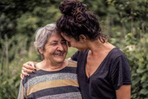 A senior woman and her daughter or grandaughter, highlighting the idea of caregiving tips