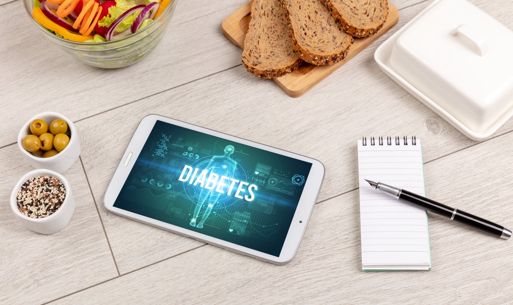 The idea of diabetes, showing an app, a notepad and some food